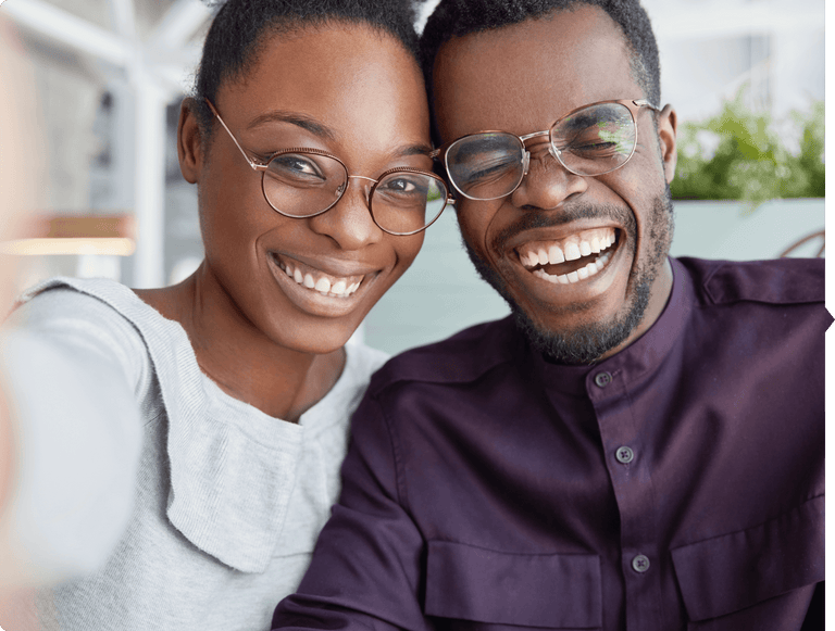 A couple wearing reading glasses smiling and enjoying life