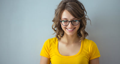 girl in a yellow shirt wearing blue light glasses