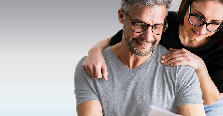 man and woman looking at tablet wearing glasses