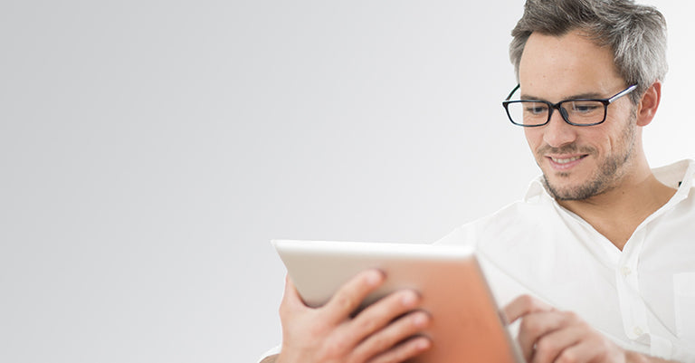 man using tablet wearing glasses